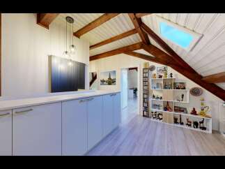 Discover this charming attic space featuring exposed wooden beams and a skylight that floods the area with natural light.