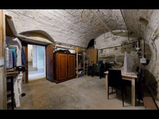 Discover this unique basement space featuring a rustic stone and arched ceiling, perfect for storage or a workshop.