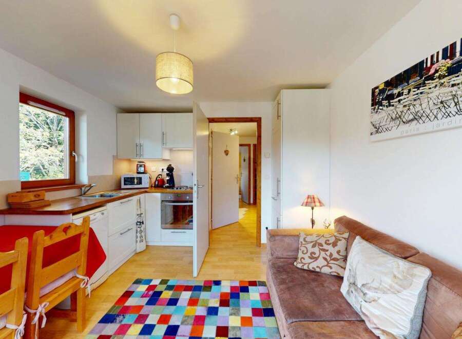 This compact living space features a well-equipped kitchenette with modern appliances and ample counter space, perfect for preparing meals.