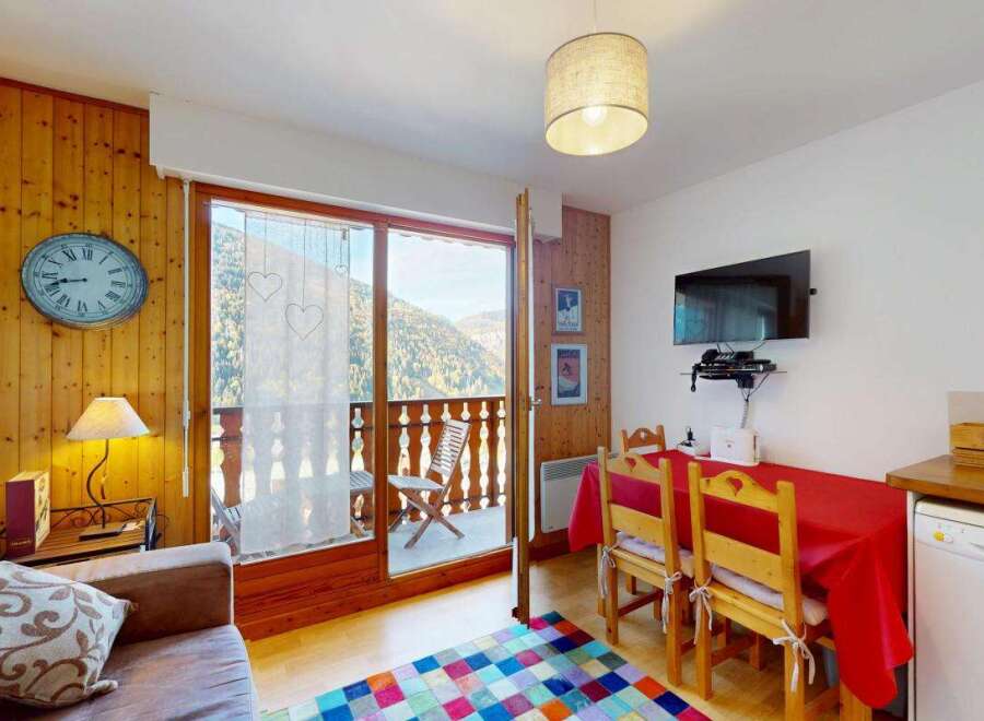 Enjoy breathtaking mountain views from this charming apartment, featuring a cozy living area with a comfortable sofa and a dining space perfect for meals.