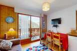 Enjoy breathtaking mountain views from this charming apartment, featuring a cozy living area with a comfortable sofa and a dining space perfect for meals.