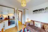 This charming apartment features a modern, well-equipped kitchen with white cabinetry, a microwave, and an oven, perfect for preparing meals.