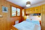 This charming bedroom features warm wood paneling throughout, creating a cozy and inviting atmosphere.