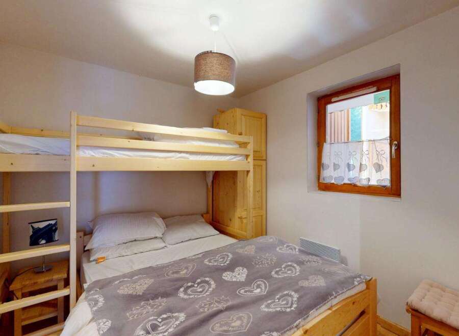 This cozy bedroom features a space-saving bunk bed, perfect for families or accommodating guests.