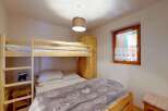 This cozy bedroom features a space-saving bunk bed, perfect for families or accommodating guests.