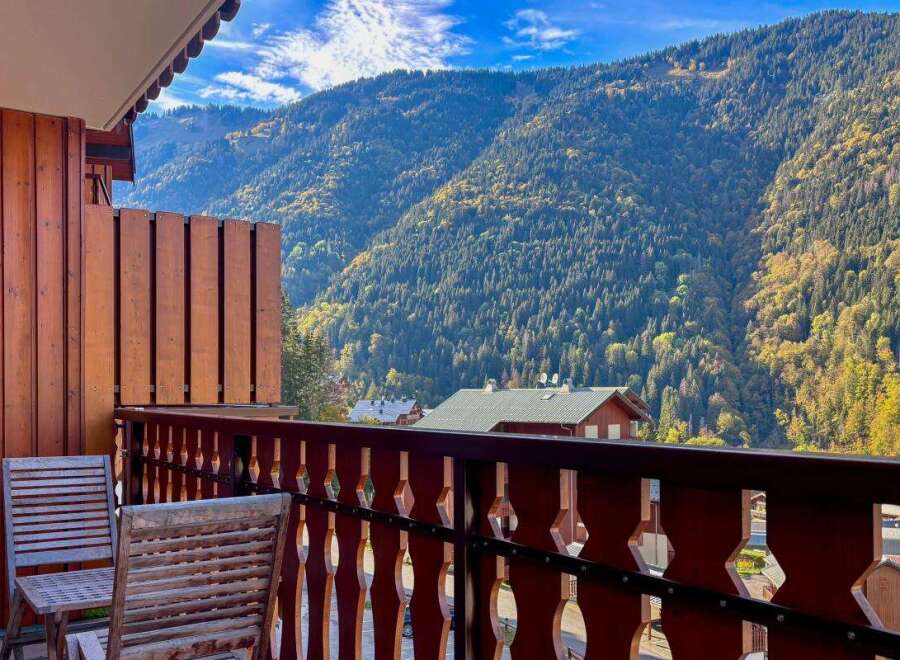 Enjoy breathtaking mountain views from this charming balcony, complete with two wooden chairs perfect for morning coffee or evening relaxation.