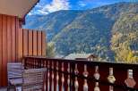 Enjoy breathtaking mountain views from this charming balcony, complete with two wooden chairs perfect for morning coffee or evening relaxation.