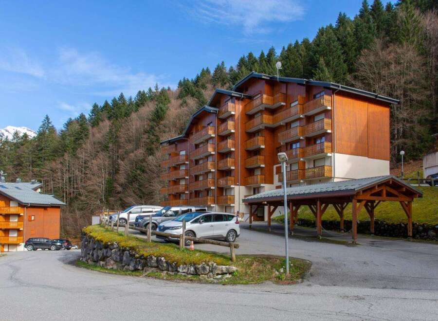 Experience mountain living in this charming wooden apartment building, nestled against a backdrop of lush pine forests and snow-capped peaks.