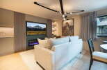 Experience modern living in this stylish living room, featuring a sleek fireplace and a large flat-screen TV mounted above it.