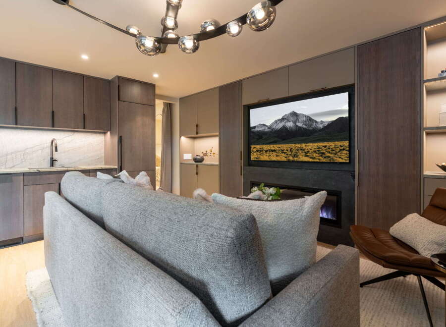 Experience modern living in this stylish apartment, featuring a sleek kitchen with marble countertops and dark wood cabinetry.