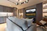 Experience modern living in this stylish apartment, featuring a sleek kitchen with marble countertops and dark wood cabinetry.