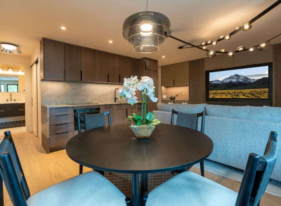 Experience modern living in this stylish studio apartment, featuring a sleek kitchen with dark wood cabinetry and a marble backsplash.