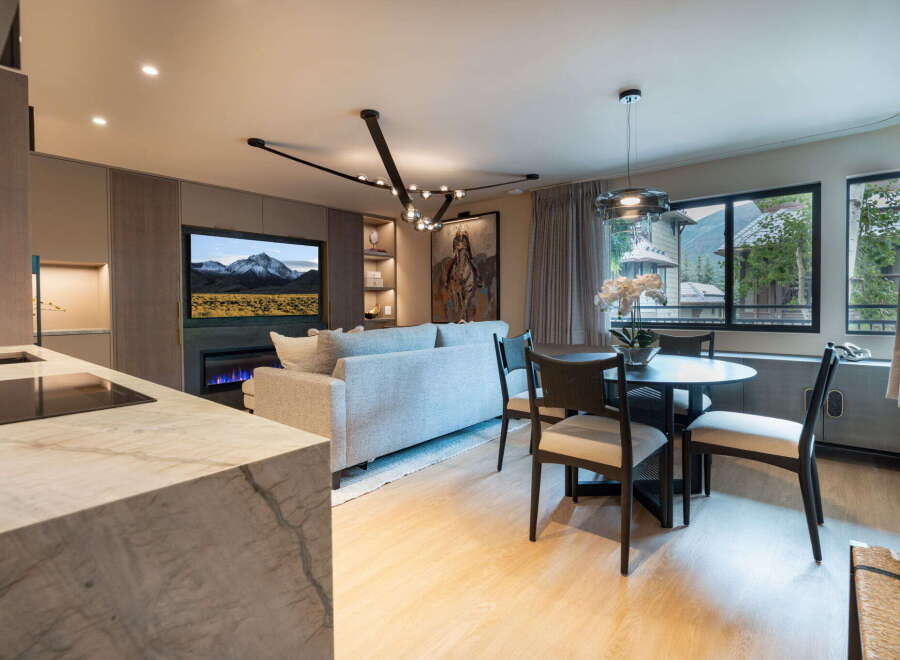 Experience modern living in this beautifully appointed open-concept space, featuring a sleek kitchen island with a marble countertop and integrated stovetop.