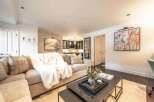 Experience modern living in this beautifully appointed living space, featuring a plush sectional sofa draped with a luxurious faux fur throw.