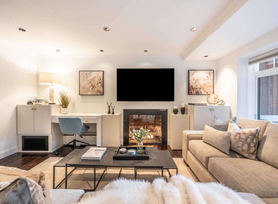 Experience modern living in this stylish living room, featuring a sleek fireplace and a large flat-screen TV.