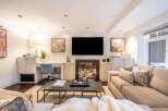 Experience modern living in this stylish living room, featuring a sleek fireplace and a large flat-screen TV.