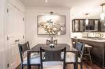 This elegant dining area features a dark wood table set with four chairs upholstered in neutral fabric and accented with woven backs.