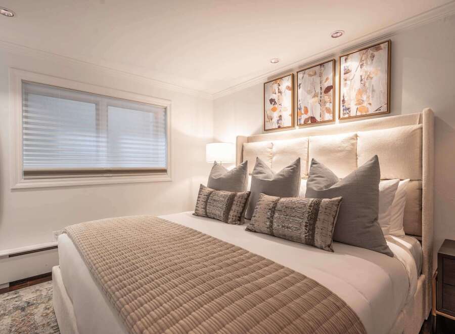 Experience luxurious comfort in this beautifully appointed bedroom, featuring a king-size bed with plush pillows and a textured throw.