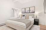 Experience serene mountain views from this beautifully appointed bedroom, featuring a plush king-sized bed and tasteful abstract art.