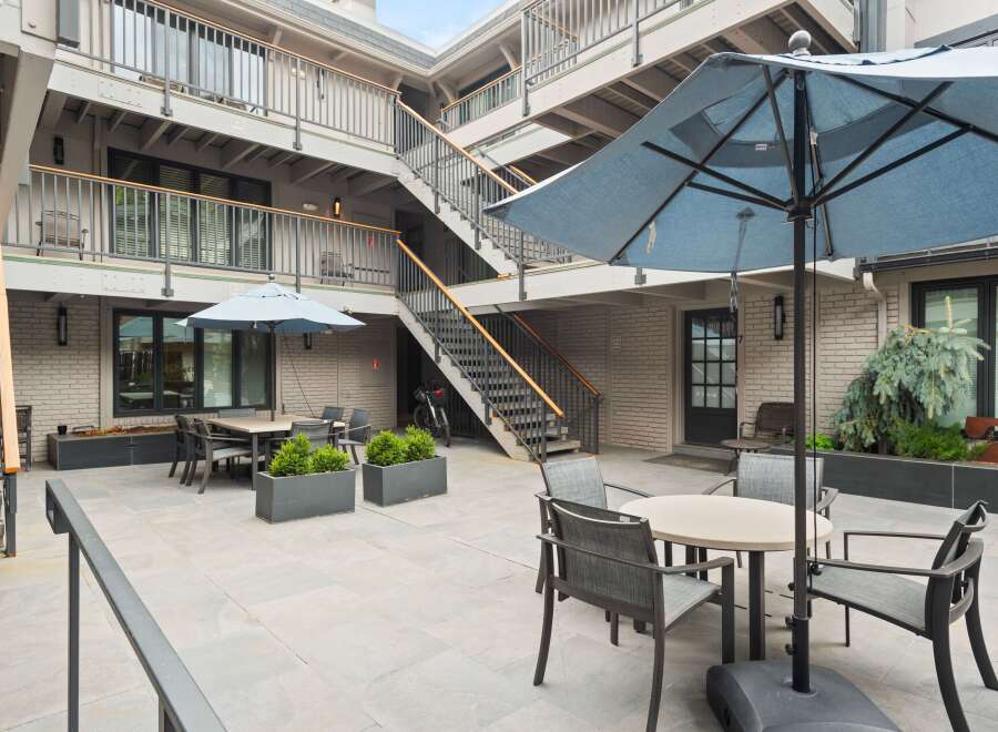 Enjoy outdoor living in this charming courtyard featuring ample seating and dining areas.