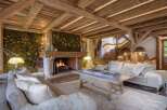 Experience rustic luxury in this stunning living room, featuring exposed wooden beams and a moss-covered accent wall adorned with decorative birds.