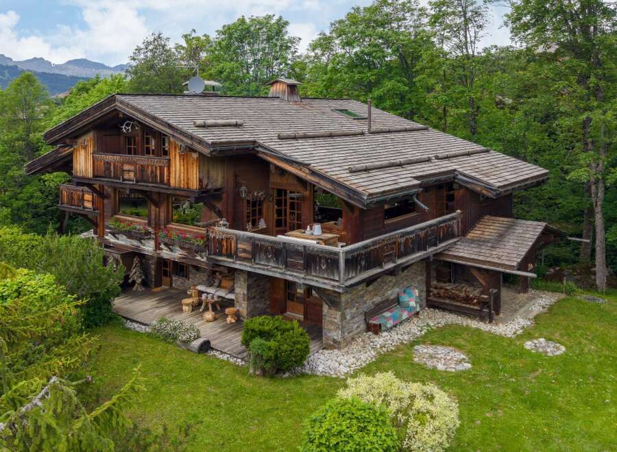 Experience the charm of this stunning wooden chalet nestled amidst lush greenery and majestic mountains.
