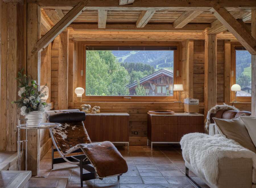 Experience rustic luxury in this charming wooden chalet, featuring a spacious living area with a stunning mountain view.