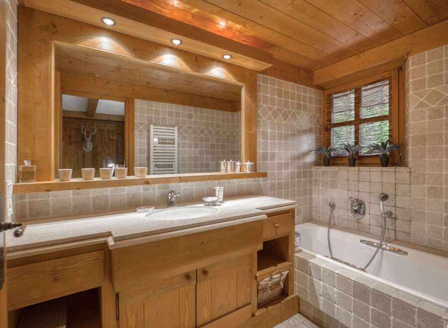 Experience rustic charm in this beautifully appointed bathroom, featuring warm wooden accents throughout the ceiling, cabinetry, and trim.