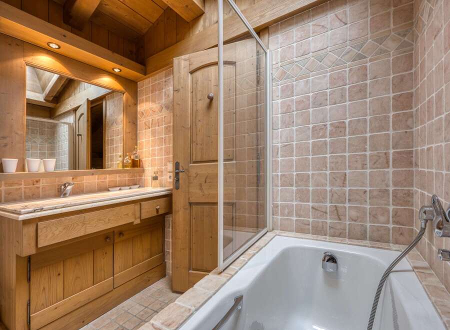 Experience rustic charm in this beautifully appointed bathroom, featuring warm wooden accents and a luxurious bathtub.