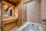 Experience rustic charm in this beautifully appointed bathroom, featuring warm wooden accents and a luxurious bathtub.