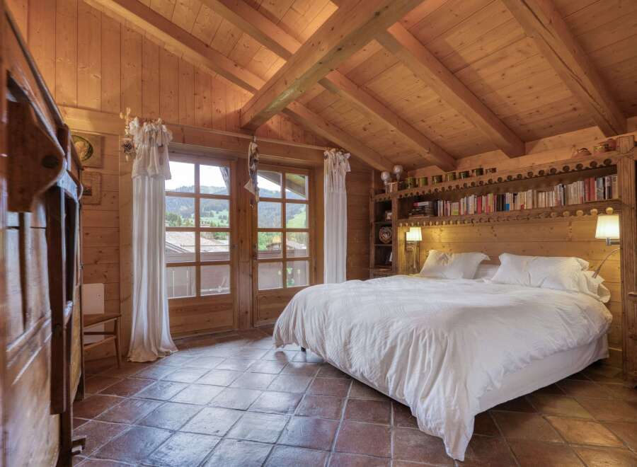 Experience rustic charm in this beautifully appointed bedroom, featuring a cozy king-sized bed with crisp white linens.