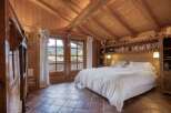 Experience rustic charm in this beautifully appointed bedroom, featuring a cozy king-sized bed with crisp white linens.