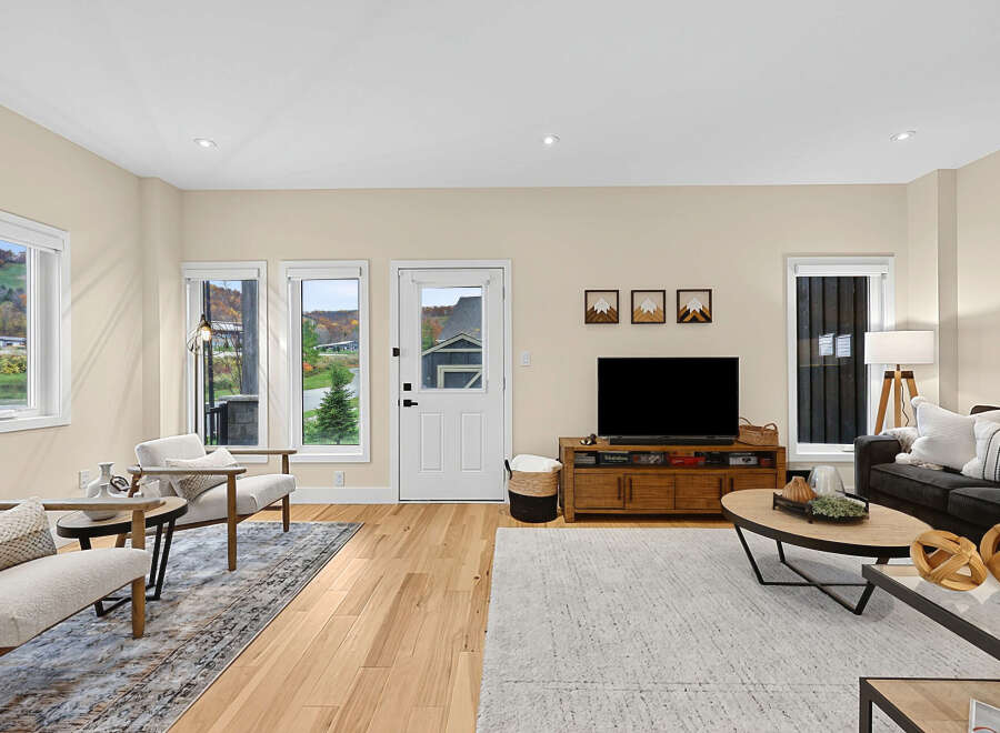 Step into this inviting living room, featuring a cozy seating area with plush chairs and a stylish sofa, perfect for relaxation.
