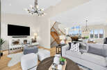 Experience modern living in this spacious open-concept home, featuring a stunning vaulted ceiling with a contemporary chandelier and a large flat-screen TV mounted above a sleek soundbar.