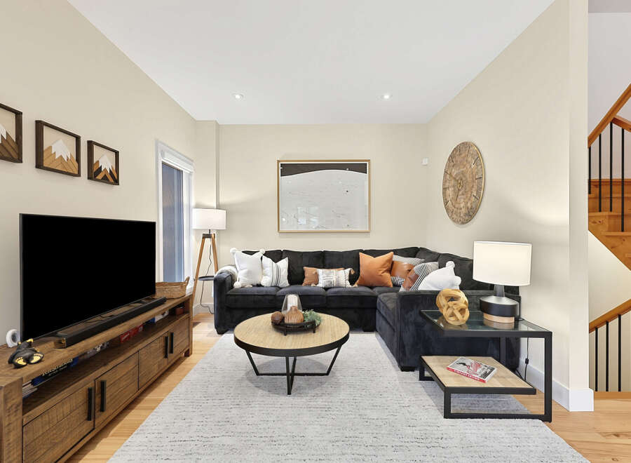 Step into this inviting living room, featuring a spacious sectional sofa adorned with plush pillows and a stylish coffee table.