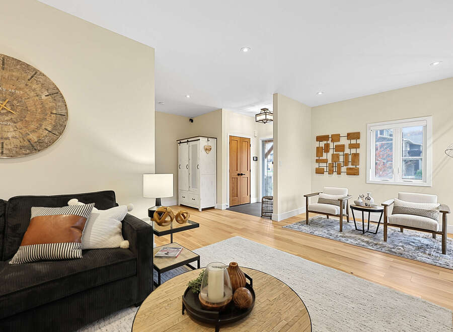 Step into a beautifully appointed living space featuring a plush charcoal sofa adorned with stylish throw pillows, perfect for cozy evenings.