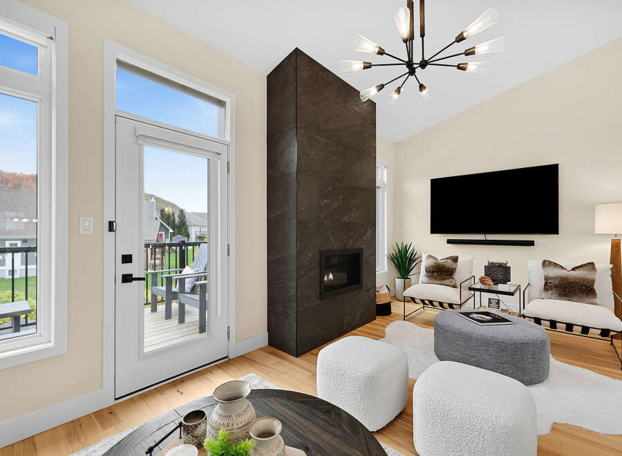 Experience modern living in this stylish living room, featuring a dramatic floor-to-ceiling dark stone fireplace as the centerpiece.