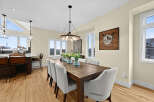 Experience modern living in this stunning dining area, featuring a spacious wooden table perfect for gatherings.