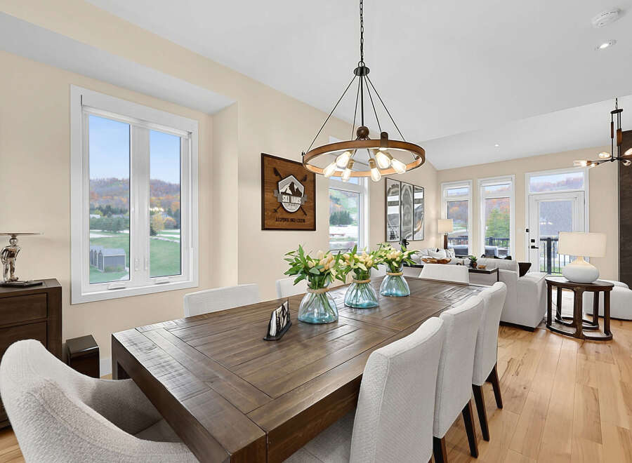 Experience elegant dining in this beautifully appointed space, featuring a rustic wooden table and plush, upholstered chairs.