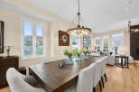 Experience elegant dining in this beautifully appointed space, featuring a rustic wooden table and plush, upholstered chairs.