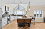 Experience modern living in this stunning kitchen featuring sleek white cabinetry, a dramatic dark backsplash, and a spacious island perfect for entertaining.