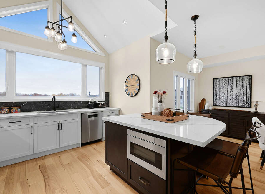 Experience modern living in this stunning kitchen featuring a spacious island with a built-in microwave and ample seating.