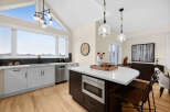 Experience modern living in this stunning kitchen featuring a spacious island with a built-in microwave and ample seating.