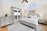 Experience coastal charm in this serene bedroom, featuring a rustic wooden bed and matching nightstands.