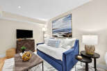 This living area features a plush blue velvet daybed adorned with white and blue patterned pillows, perfect for relaxation.