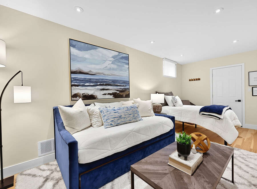 This versatile room offers comfortable sleeping arrangements with a plush blue daybed and a twin bed, perfect for guests or a multi-functional living space.