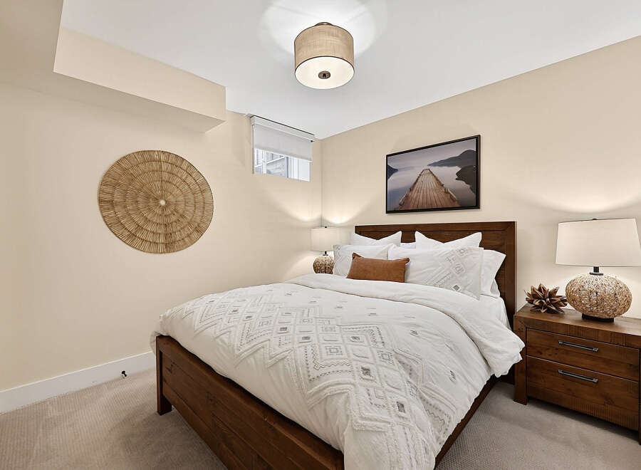 This cozy bedroom features a plush white duvet with intricate geometric patterns, complemented by a warm, rustic wooden bed frame.