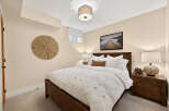 This cozy bedroom features a plush white duvet with intricate geometric patterns, complemented by a warm, rustic wooden bed frame.