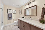 This beautifully appointed bathroom features a modern vanity with a quartz countertop, complemented by a sleek chrome faucet.