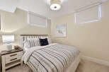 This cozy bedroom features a comfortable queen-size bed with a striped duvet and plush pillows, perfect for a restful night's sleep.